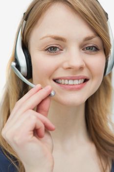 Woman with headset looking at camera against a white background