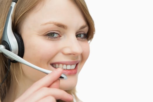 Woman with headset smiling against a white background