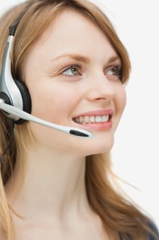 Close up of a woman with headset smiling against a white background