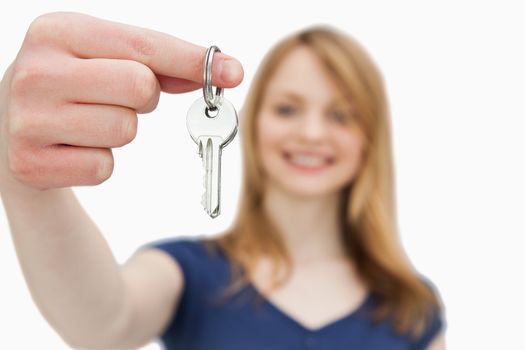 Focus shot on a woman holding a key against a white background