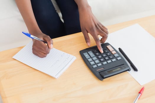 Close up of a woman using a calculator in a living room