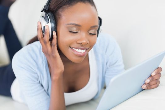 Black woman listening music with closed eyes in a living room