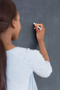Focus on a black woman holding a chalk in classroom