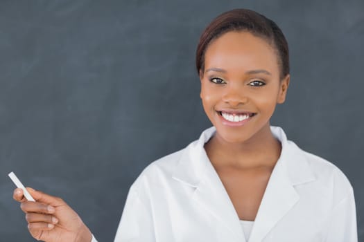 Front view of a black woman holding a chalk in a classroom