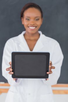 Focus on a black woman holding a tablet computer in a classroom