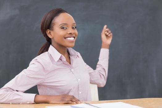 Black teacher showing the blackboard in a classroom
