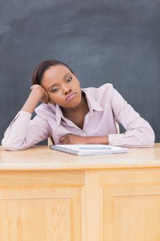 Sad black woman at desk in a classroom