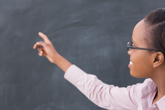 Black teacher pointing the blackboard in a classroom