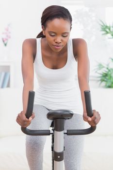 Woman doing exercise bike in a living room