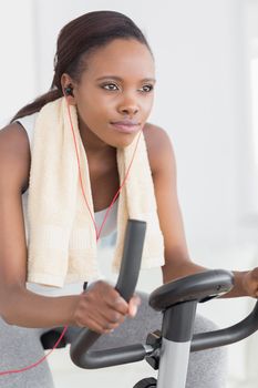 Concentrated black woman doing exercise bike in a living room