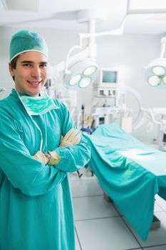 Surgeon with arms crossed smiling in an operating theatre