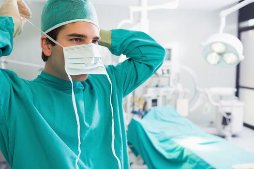 Surgeon putting his mask in an operating theatre