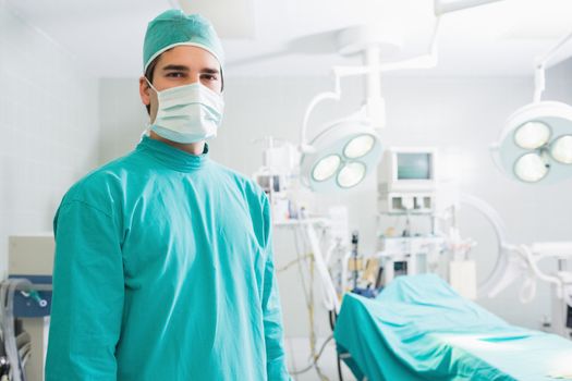 Surgeon standing in an operating theatre with a mask