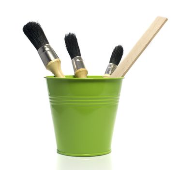 green bucket with paint brushes isolated on white