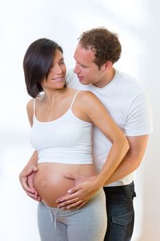 Beautiful pregnant woman with husband couple in a hug