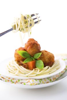 Delicious spaghetti on a fork close-up, plate spaghetti as background