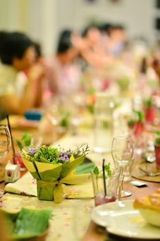 Reunion party in warm ambient , focus on the flower bouquet on dining table.