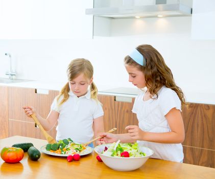 Beautiful chef sisters at home kitchen preparing salad