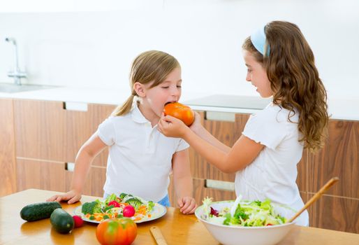 Beautiful chef sisters at home kitchen preparing salad