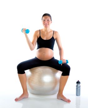Beautiful pregnant woman at fitness gym with dumbells on aerobics ball