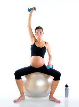 Beautiful pregnant woman at fitness gym with dumbells on aerobics ball