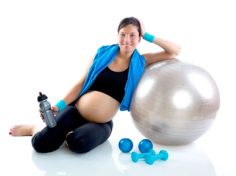 Beautiful pregnant woman at fitness gym relaxed with aerobics ball