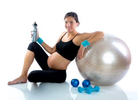Beautiful pregnant woman at fitness gym relaxed with aerobics ball