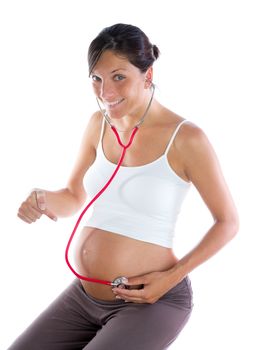 Beautiful pregnant woman as self doctor with stethoscope checking her belly