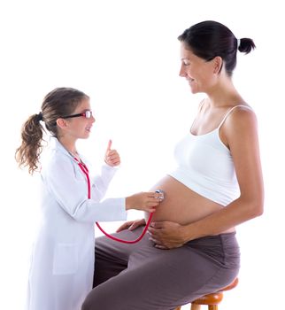 Beautiful pregnant woman and kid girl as doctor with stethoscope checking her belly