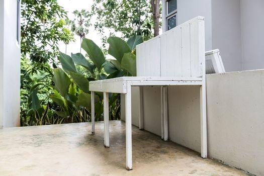 Empty white wooden chair at home terrace.