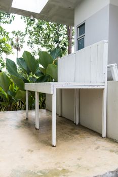 Empty white wooden chair at home terrace.