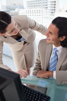 Portrait of a smiling business team using a monitor in an office