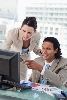 Portrait of a business team studying statistics while using a monitor in an office