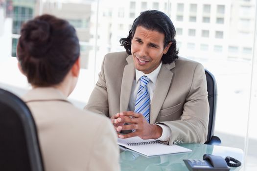 Smiling manager interviewing a female applicant in his office