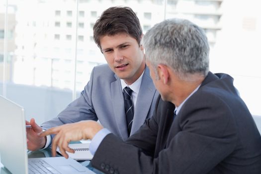 Businessmen working with a laptop in an office