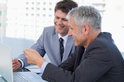 Businessmen working with a notebook in an office