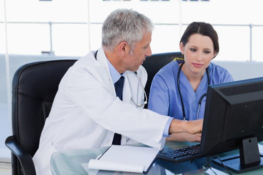 Medical team working together with a computer in an office