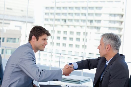Serious businessmen shaking hands in an office