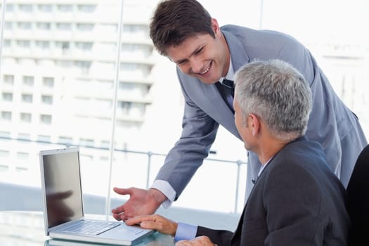 Side view of smiling businessmen working with a notebook in an office