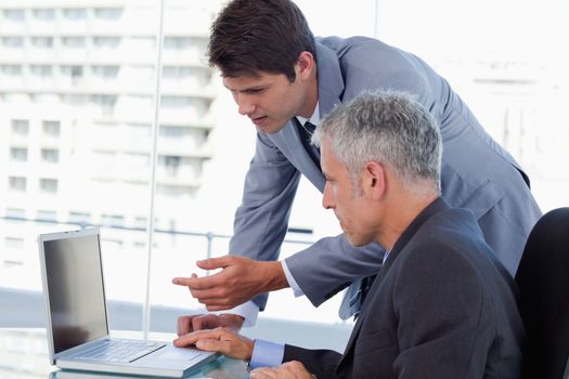 Side view of businessmen working with a laptop in an office