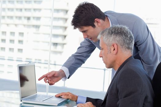Side view of businessmen working with a notebook in an office