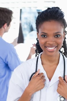 Portrait of a doctor looking at a of X-ray while his colleague is smiling in an office