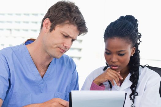 Doctors looking at a document in an office
