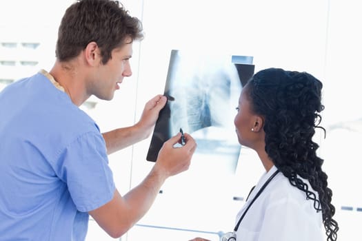 Happy doctors looking at a of X-ray in an office
