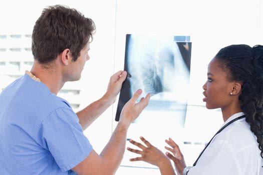 Young doctors looking at a of X-ray in an office