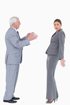 Businesswoman getting accused by colleague against a white background