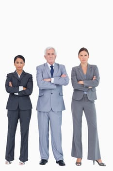 Three businesspeople with arms folded against a white background