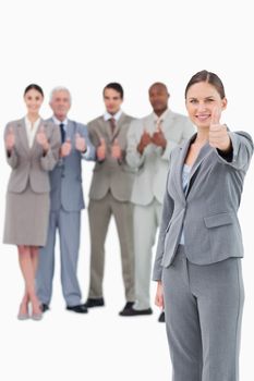 Saleswoman with thumb up and her team behind her against a white background