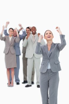Cheering businesswoman with team behind her against a white background