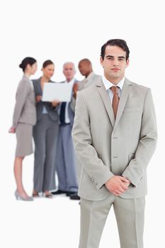 Confident businessman with team behind him against a white background